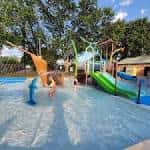 Niños jugando en la piscina del área recreativa del Quillian Center bajo un día soleado