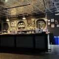 Bar interior del teatro con estanterías decorativas y ambiente industrial