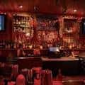 Vista del bar principal con estanterías llenas de botellas y ambiente acogedor