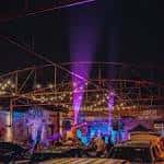 Escenario iluminado con efectos de luz púrpura durante una presentación en vivo