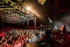 Interior del venue con público y luces de escenario