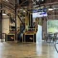 Interior del Bad Astronaut Brewing Co. con zona de eventos y pantalla