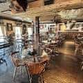 Interior del restaurante con mesas dispuestas para celebración y decoración rústica