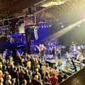 Concierto en vivo con banda en el escenario e iluminación profesional