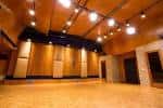 Sala de eventos vacía con escenario y sistema de sonido profesional