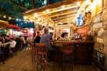 Interior acogedor del bar con clientes sentados en el mostrador y decoración rústica