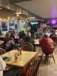 Interior del restaurante Kojak's con mesas ocupadas y ambiente acogedor