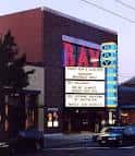 Entrada principal del teatro con cartelera de películas y diseño arquitectónico distintivo