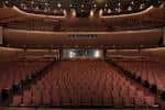 Interior del auditorio mostrando las butacas rojas y el escenario