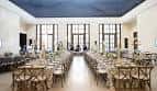 Salón interior preparado para eventos con mesas y sillas decoradas