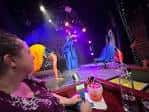 Escenario iluminado con luces de colores y artistas actuando