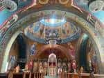 Vista interior de la iglesia con cúpula decorada y altar central