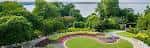 Panorámica del jardín central con senderos curvos y vegetación densa junto al lago