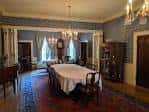 Salón histórico con mesa redonda cubierta, alfombra roja y decoración clásica ideal para recepciones