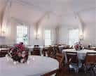 Sala de banquetes con mesas redondas decoradas y arcos en el techo, perfecta para eventos sociales