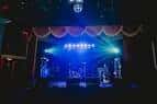 Escenario iluminado con banda en vivo durante un evento