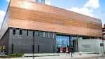 Fachada principal del museo con detalles arquitectónicos en madera y hormigón