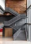 Escalera interior moderna con estructura metálica y paredes de ladrillo