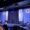 Escenario vacío del club con cortinas y luces azules