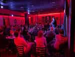 Espectáculo de comedia en vivo con audiencia bajo iluminación roja