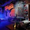 Bar interior de Ruins con iluminación tenue y decoración artística