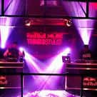 Escenario del It'll Do Club con luces de neón y DJ en acción