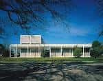 Vista exterior del edificio principal del Museo Menil con su característica estructura de celosía y columnas blancas bajo un cielo azul