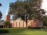 Vista exterior de la Westminster United Methodist Church con fachada de ladrillo y torre blanca