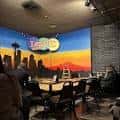 Interior del club de comedia con escenario y mural de Seattle