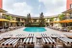 Piscina exterior del Hotel ZaZa con tumbonas y sombrillas bajo el cielo diurno