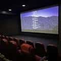 Interior del cine Digital Gym Cinema con butacas rojas y pantalla proyectando paisaje
