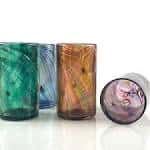 Conjunto de vasos de vidrio coloridos y un plato decorativo