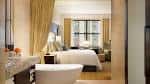 Habitación de lujo con cama king-size, baño independiente y vista a la ciudad