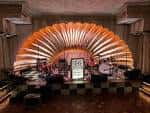 Escenario principal con diseño de abanico iluminado en tonos cálidos