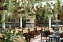 Interior del restaurante con decoración de jardines y mesas dispuestas para eventos