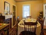 Sala de comedor histórica decorada con mesa servida y mobiliario antiguo