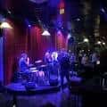 Escenario interior con banda tocando jazz bajo luces azules