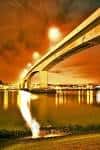 Vista nocturna del Itchen Bridge con reflejos en el agua y cielo anaranjado
