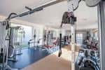 Interior del gimnasio del polideportivo con equipamiento deportivo moderno y grandes ventanales