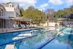 Piscina exterior del club con tumbonas y zona de descanso