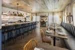 Interior elegante del restaurante Lenoir con barra larga y mesas dispuestas para eventos