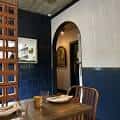 Detalle de zona interior con decoración azul y arco, ideal para recepciones o cenas íntimas