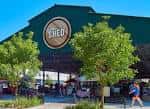 Fachada del edificio 'The Shed' en el Dallas Farmers Market con visitantes caminando