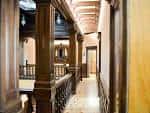 Pasillo interior con columnas de madera y detalles arquitectónicos históricos