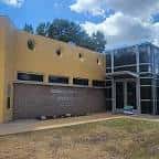 Vista exterior del Rodolfo "Rudy" Mendez Recreation Center con fachada amarilla y entrada moderna