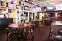 Interior del bar con mesas y ambiente festivo