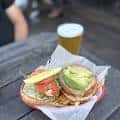 Plato de comida típica con cerveza en mesa al aire libre