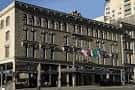 Fachada exterior del Alexis Royal Sonesta Hotel Seattle con banderas internacionales