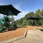 Área de juegos infantil con toboganes y sombra en Metz Neighborhood Park