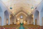 Interior de la iglesia con bóveda abovedada y bancos de madera
